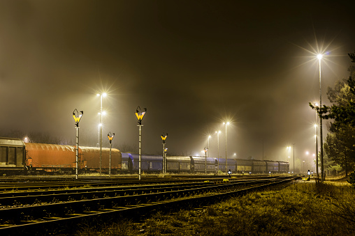 Nocturnal marshalling yard in the fog. Freight wagons are on the tracks at Ziltendorf, Brandenburg, Germany.