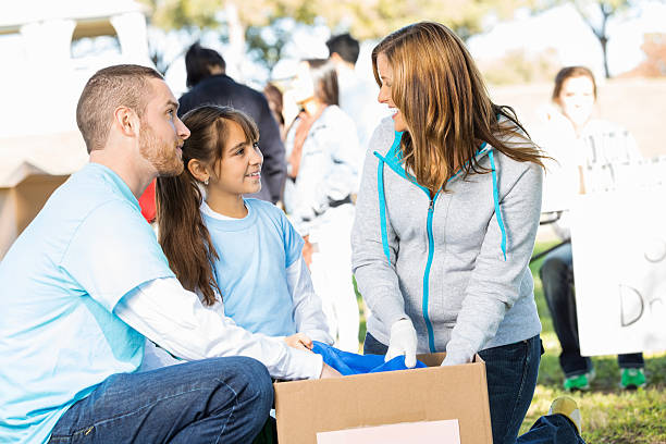 istock Parents and daughter volunteering together, sorting donations 472096433