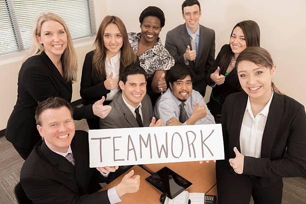 istock Business:  Group of professionals hold 'teamwork' sign. 472096507