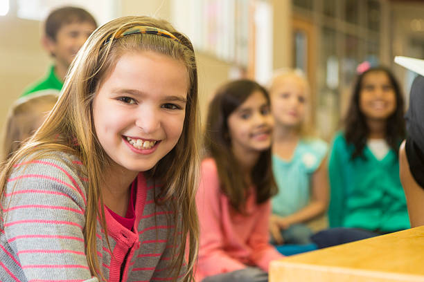 istock Happy little girl smiling during story time at elementary school 472096509