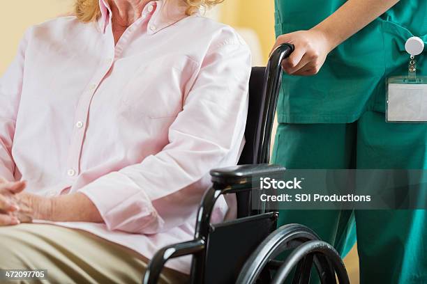 Enfermera Pusing Paciente De Edad Avanzada En Silla De Ruedas Centrarse En Las Manos Foto de stock y más banco de imágenes de 70-79 años