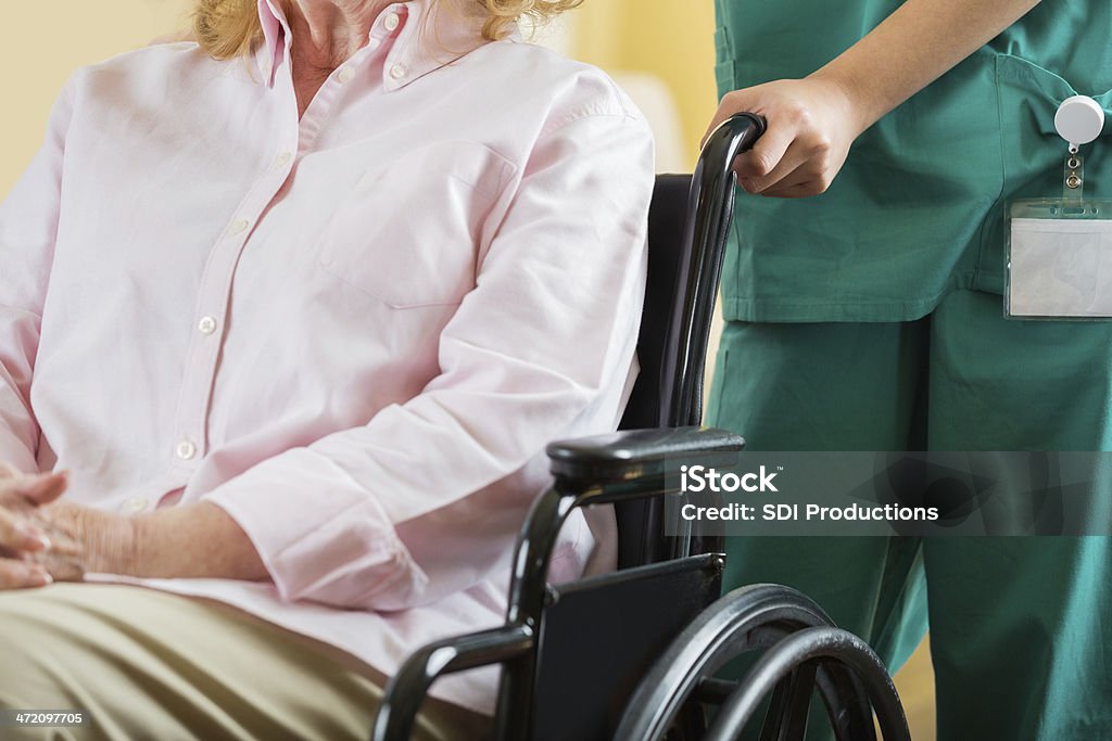 Infirmière pusing personnes âgées patient en fauteuil roulant, gros plan sur les mains - Photo de Adulte libre de droits