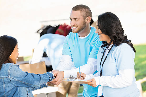 istock Happy volunteers accepting donations from Asian woman 472098043