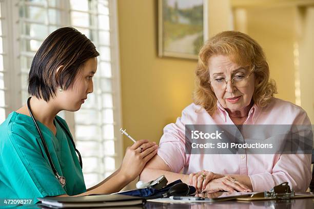Senior Mujer Recibiendo La Inyección De Su Personal De Enfermería De Atención Médica Foto de stock y más banco de imágenes de Doctora