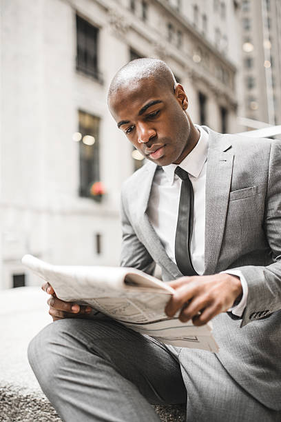 istock business man reading a newspaper on wall street 472098775
