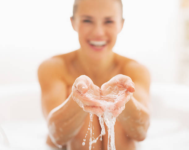 istock closeup on smiling young woman splashing water 472099541