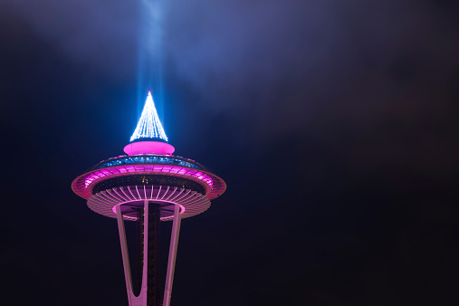 Seattle, USA - December 31, 2013: The Space Needle illuminated in pink just before midnight on New Years Eve with a foggy sky. 