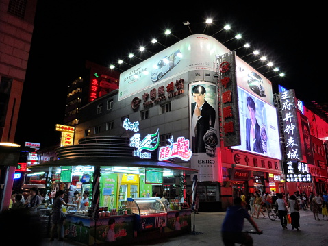 Beijing, China – July 2, 2013: Tourists and locals walk at Wangfujing Street, Beijing, China. It is one of famous shopping streets in Beijing. It is also famous for local food and souvenirs.