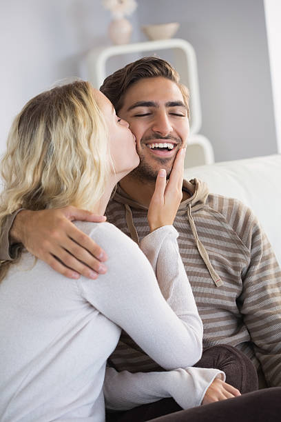 istock Girlfriend kissing cheerful boyfriend on cheek 472100965