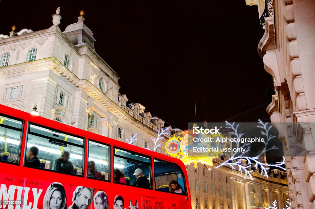 Double decker bus passing under Christmas Lights in London London, United Kingdom - December 15, 2013: Passengers sat on a double decker bus in London's Piccadilly Circus as the bus passes under some Chridtmas Lights advertising 'Peabody and Sherman' animated movie. Some of the passengers are looking out of the window directly at the camera. The image used a high ISO and was post proceesed in HDR software and Photoshop to reduce noise. Architecture Stock Photo