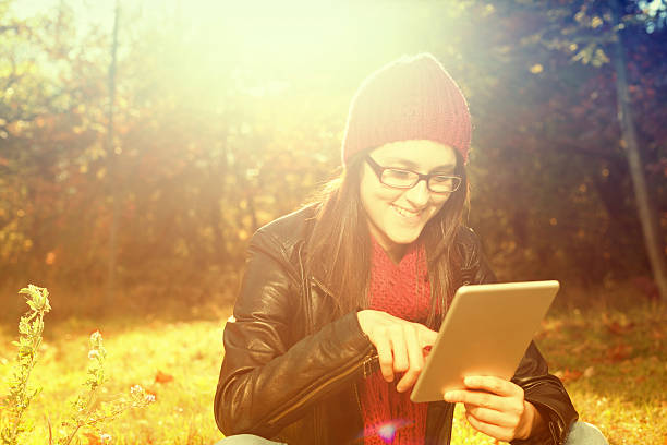 surfer sur le net - women grass glasses e reader photos et images de collection