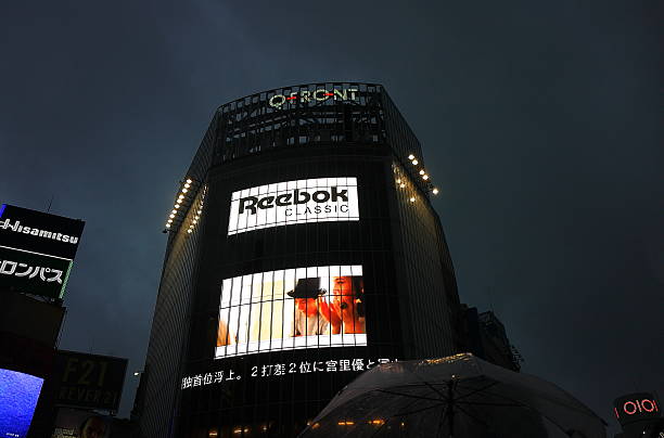 Fashion trademarks in Tokyo Tokyo, Japan - October 5: Main trademarks advertise their business on the most commercial facades of downtown on October 5,2013 in Tokyo, Japan. reebok stock pictures, royalty-free photos & images