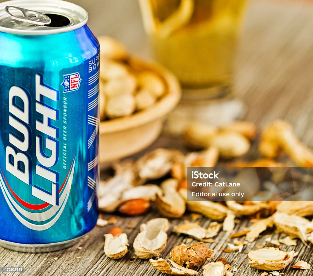Beer and Peanuts Suffolk, Virginia, USA - January 4, 2014: A square format studio shot of an opened can of Bud Light beer and some Virginia grown peanuts. In the background is a glass filled with Bud Light beer. Alcohol - Drink Stock Photo