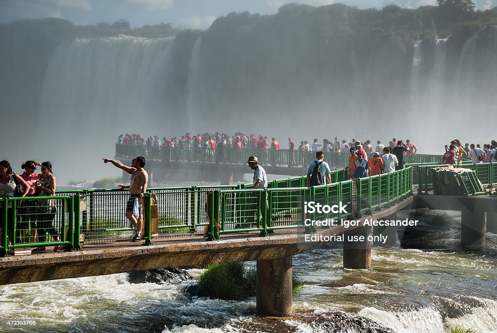 Tourists at Iguazu Falls in Brazil Foz do Iguacu, Paraná, Brazil - January 7, 2009: Tourists walking on the catwalks of Iguaçu National Park. Located on the border between Brazil and Argentina, the Iguazu Falls receive many tourists every year. Iguacu River Stock Photo