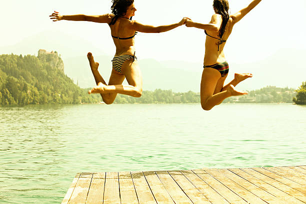 Enjoying forest party with friends. Group of beautiful happy young men and girls swimming at the river together. Summer, party, adventure, youth, frienship concept