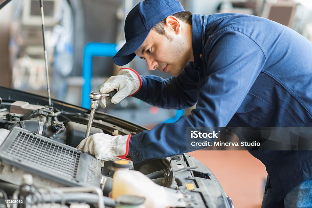 Auto mechanic working on a car in his garage Auto Mechanic Stock Photo