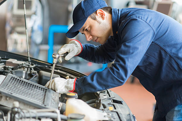 Auto mechanic working on a car in his garage stock photo