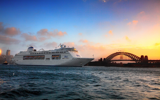 Cruise ship and galleon moored at Circular Quay, an international passenger shipping port, public piazza and tourism precinct and heritage area in Sydney, New South Wales. In the distance, the iconic Opera House.