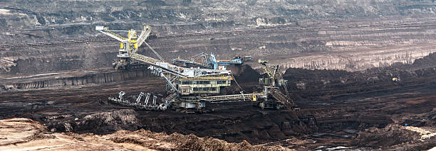 istock Open Strip Coal mine with Bucket-wheel excavator at conveyor belt 472106355