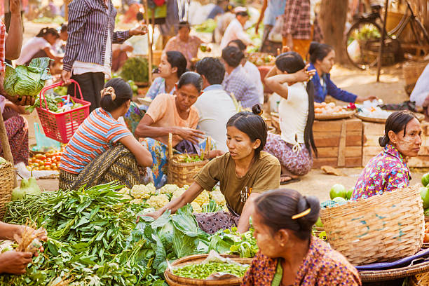 Bagan, Myanmar - February, 28th. 2010: Burmese women selling fruits and vegetable on a rural market in Bagan.