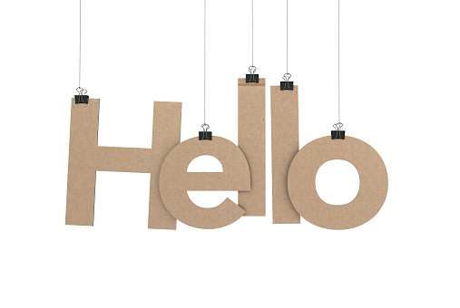 A  3D representation of the word hello hanging on a plain white background. The word is hanging from binder paper clips that are attached to a piece of string. The letters have a cardboard texture. The background is pure white. All letters are available and can be combined to form words.