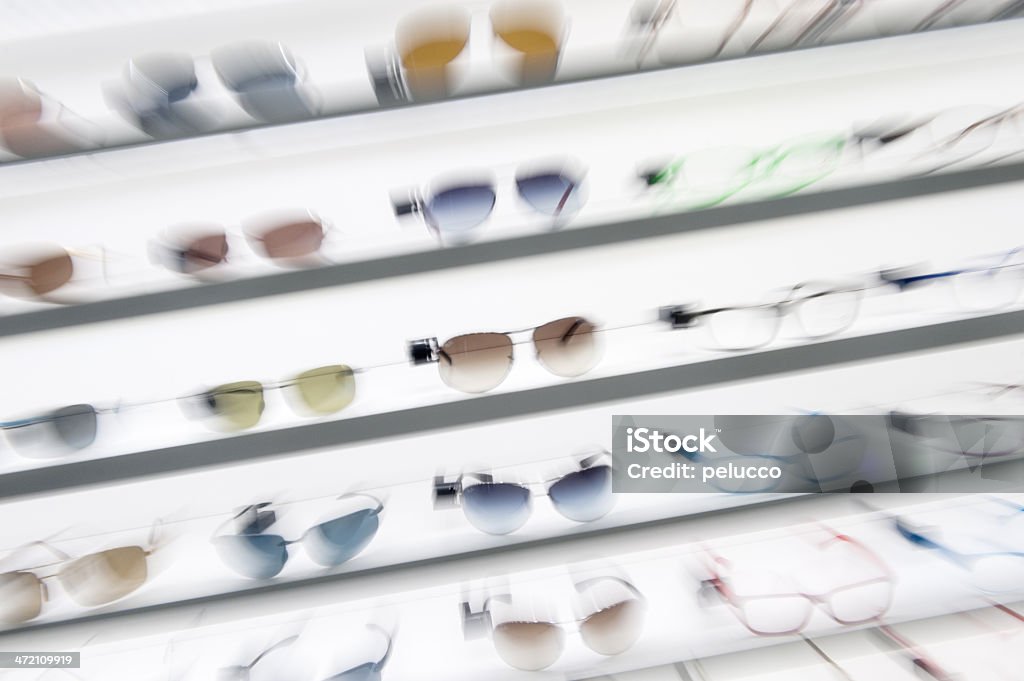 Sunglasses shop Close-up of a rows of glasses in optician shop displayed side by side on a wall. Arrangement Stock Photo