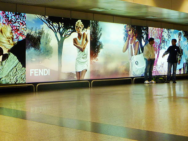 Rome, Italy-june 15, 2010 :  Walkway in Rome airport with two men talking and advertising background.