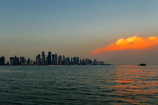Doha, Qatar - November 14, 2013: A beautiful sunset cloud adds vibrancy to the city skyline in Doha, Qatar. The West Bay is considered as one of the most prominent districts of Doha