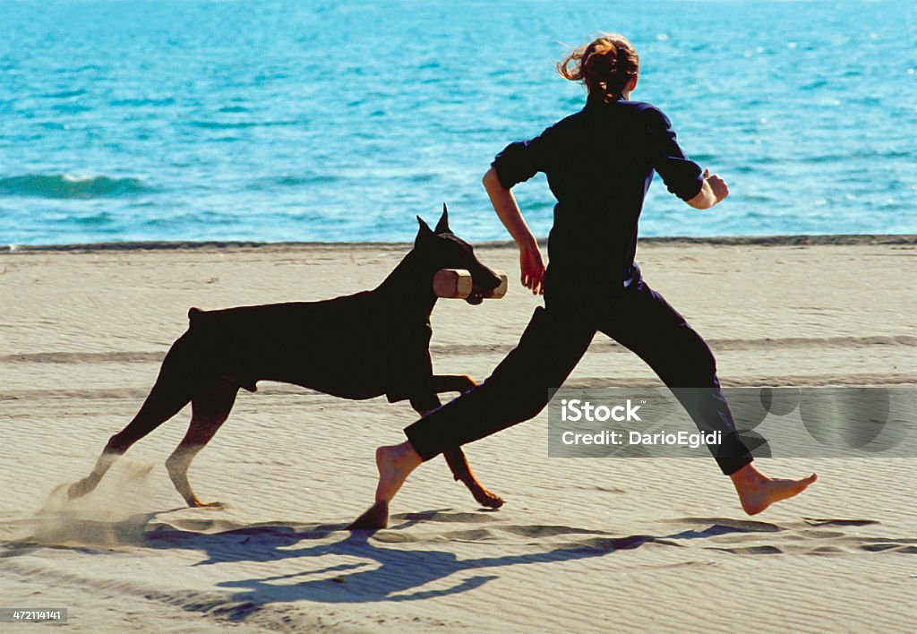 Doberman donna con cane - Foto stock royalty-free di Ambientazione esterna