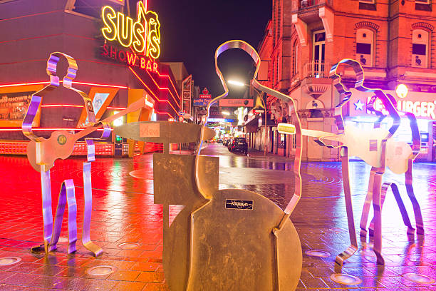 Grosse Freiheit and Beatles Platz in Hamburg Hamburg, Germany - January 6, 2014: The famous "Beatles-Platz" in Hamburg on the Reeperbahn. The four musicians are represented by their silhouettes that are standing on the edge of the place, that looks like a giant vinyl-record. In the back you can see the street "Große Freiheit" with some passants walking around, where the Beatles started their carreer in several clubs. beatles stock pictures, royalty-free photos & images