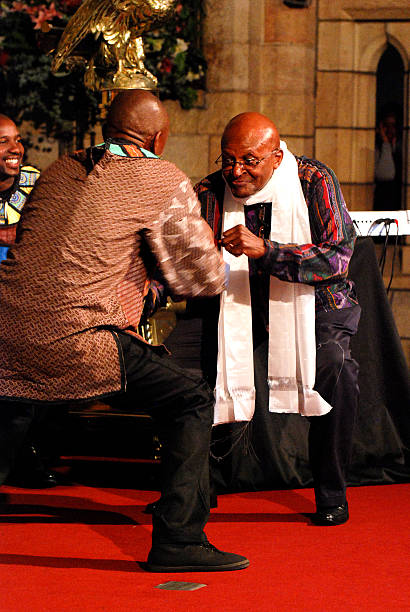 Portrait of a mid adult male Christian man sitting in an Anglican church and reading the Holy Bible. Focus is on the man, while the décor of the chapel is defocused beyond.