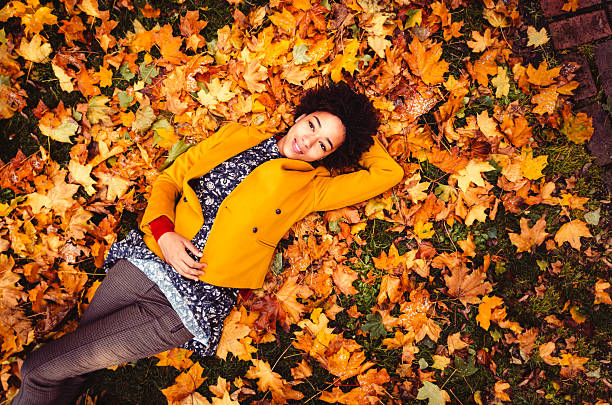 Young Woman Lying Down On Yellow Leaves