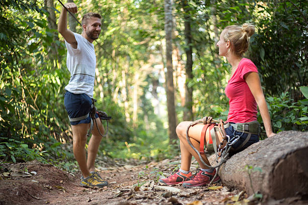 istock Young couple on a zip-line canopy tour 472115580