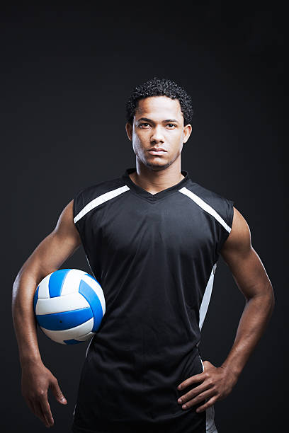 Portrait of young volleyball player. Sportsman holding a ball shoot in studio. More files of this series and model on port. Made with professional make-up. male volleyball player stock pictures, royalty-free photos & images
