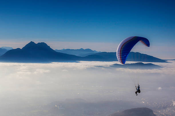 skydiving in blauen himmel - paragliding sport austria parachuting stock-fotos und bilder