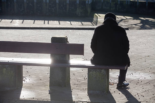 Hombre solitario en un banco de sol - foto de stock