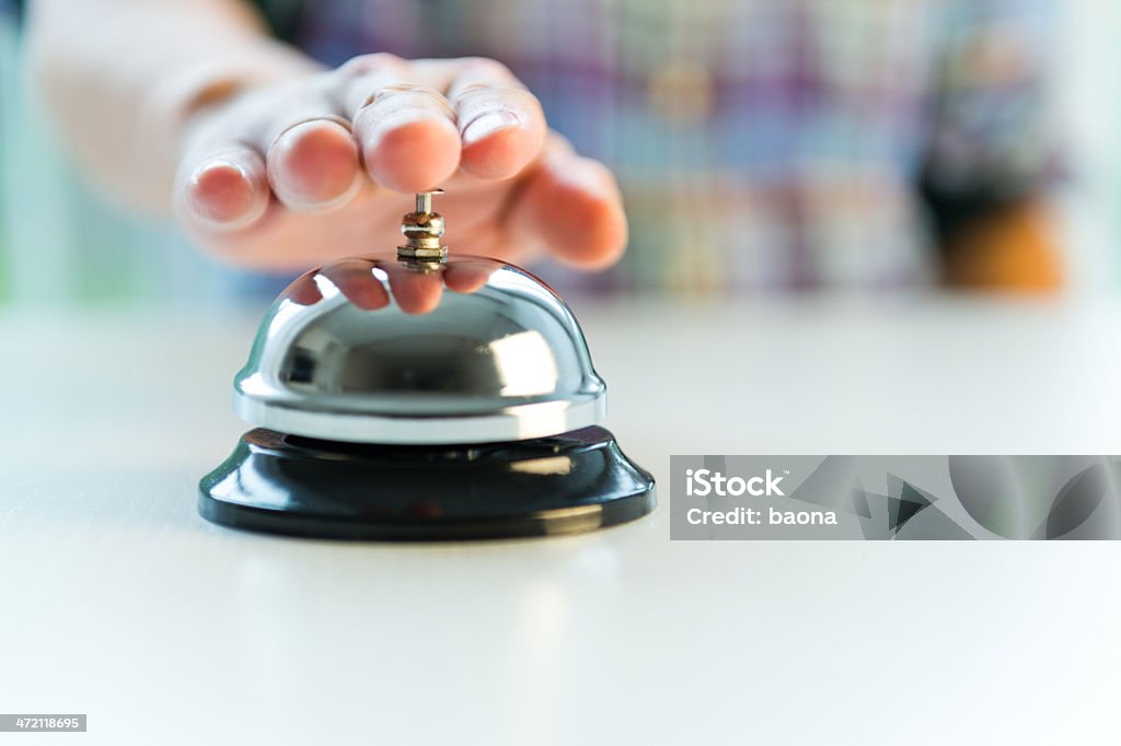 Hotel service bell with customers hand Hotel desk service bell with hand. Bell Stock Photo