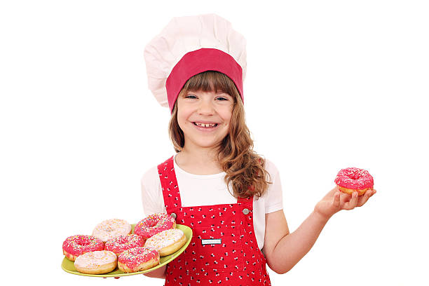 istock happy little girl cook with donuts 472119178