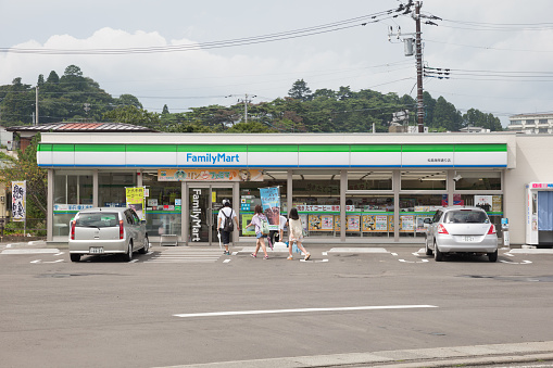 Matsushima, Japan - August 30, 2013: People walk past the FamilyMart Convenience Store in Matsushima, Miyagi Prefecture, Japan. FamilyMart is a famous convenience store chain in Japan. 