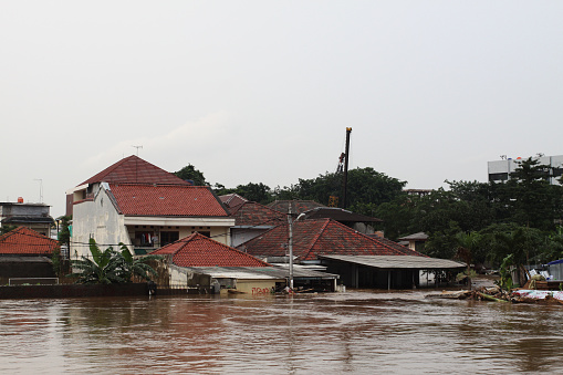 Jakarta, Indonesia-January 13, 2014: Home home on the banks of the Ciliwung river inundated by floods.