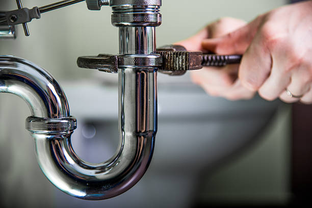 Plumber fixing a drain problem Plumber doing repair work on a drain. adjustable wrench photos stock pictures, royalty-free photos & images