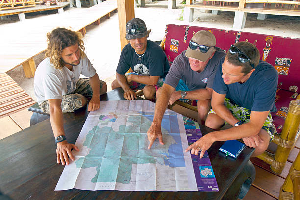 Libreville, Estuaire Province, Gabon – June 16, 2010: Group of four men in discussion with French map of Gabon.