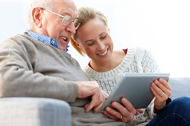 feliz pai e filha usando tablet digital em casa - senior adult child holding grandparent - fotografias e filmes do acervo