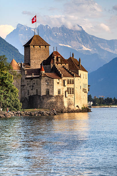 Chateau de Chillon on the shore of Lake Geneva Montreux, Switzerland - Aug 6, 2013: Chateau Chillon, Montreux, Switzerland. The Chateau de Chillon (Chillon Castle) is located on the shore of Lake Leman, at the eastern end of the lake, 3km from Montreux, Switzerland. The castle consists of 100 independent buildings that were gradually connected to become the building as it stands now. chateau de chillon photos stock pictures, royalty-free photos & images