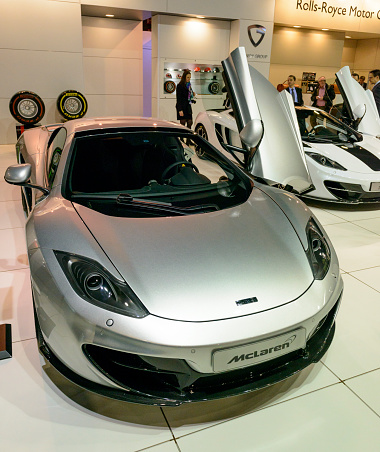 Brussels, Belgium - January 14, 2014: Silver McLaren MP4-12C sports car on display at the 2014 Brussels motor show. People in the background are looking at the cars.