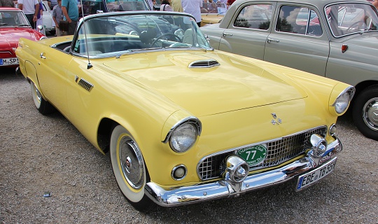 Headlights of yellow retro Chevrolet Bel Air with open car hood. 1955 Chevy at car exhibition. Snohomish, WA, USA - September 2022