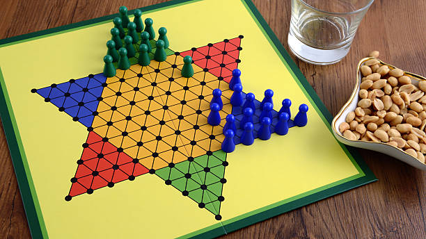 halma game board halma game board with two people playing. aside peanuts and a glass. chinese checkers stock pictures, royalty-free photos & images
