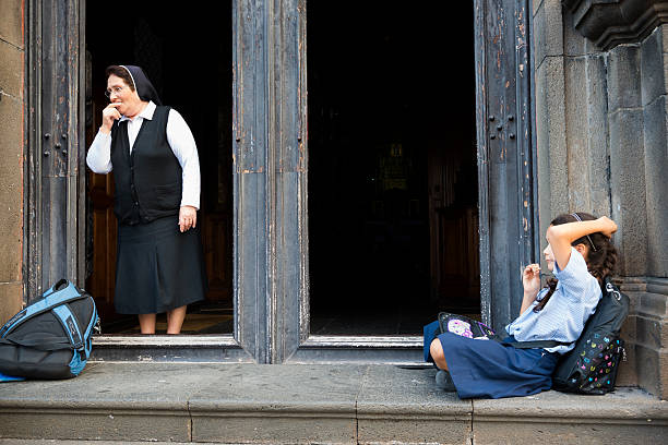 katholische nonne und school-mädchen auf kirche schritte - nun stock-fotos und bilder