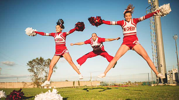 istock cheerleaders jumping team with pon-pon 472125519