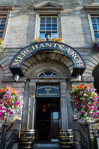 Dublin, Ireland - July 31, 2013: The Merchant's Arch Pub entrance with flowers near the Ha'penny bridge  in  Temple Bar district